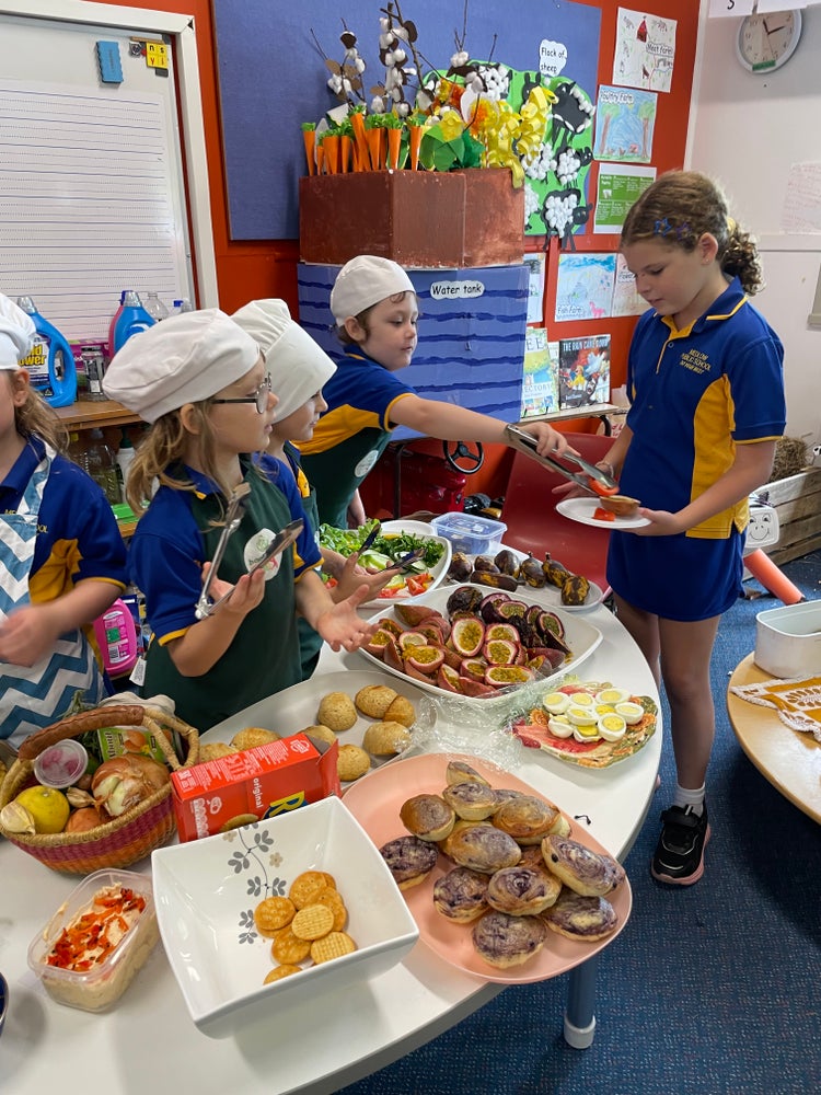photo of three students serving food to another student