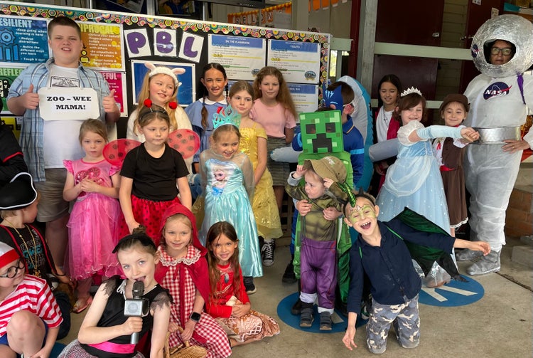 Photo of students and a teacher dressed up as characters from various books.